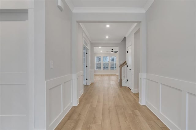 hallway featuring ornamental molding and light hardwood / wood-style floors