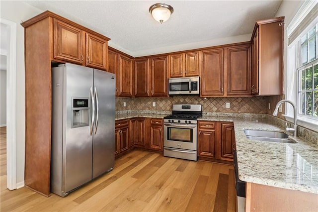 605 Alstonefield Dr, Alpharetta, GA 30004 - kitchen with stainless steel appliances, light wood finished floors, light stone counters, and decorative backsplash