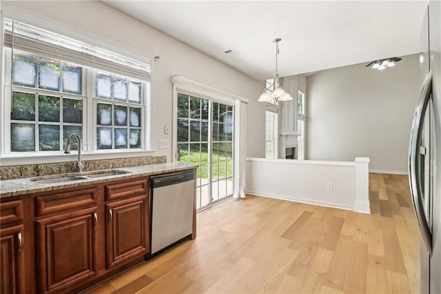 605 Alstonefield Dr, Alpharetta, GA 30004 - kitchen featuring appliances with stainless steel finishes, a chandelier, light wood finished floors, light stone counters, and decorative light fixtures