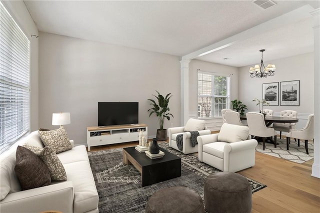 605 Alstonefield Dr, Alpharetta, GA 30004 - living room with decorative columns, wood finished floors, and a chandelier