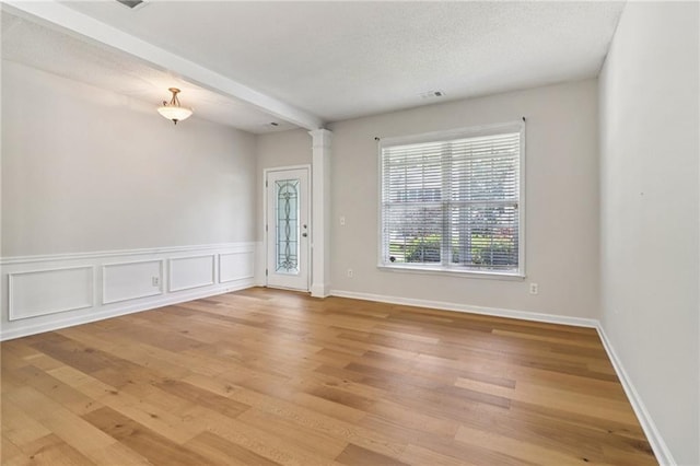 605 Alstonefield Dr, Alpharetta, GA 30004 - unfurnished room featuring light wood-style flooring, ornate columns, and a textured ceiling