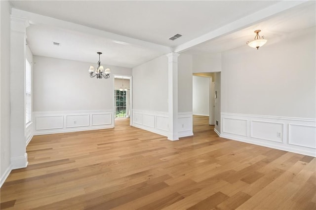 605 Alstonefield Dr, Alpharetta, GA 30004 - spare room featuring a chandelier, light wood-style flooring, decorative columns, a decorative wall, and wainscoting