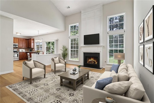 605 Alstonefield Dr, Alpharetta, GA 30004 - living area with light wood finished floors, a fireplace, a chandelier, and a towering ceiling