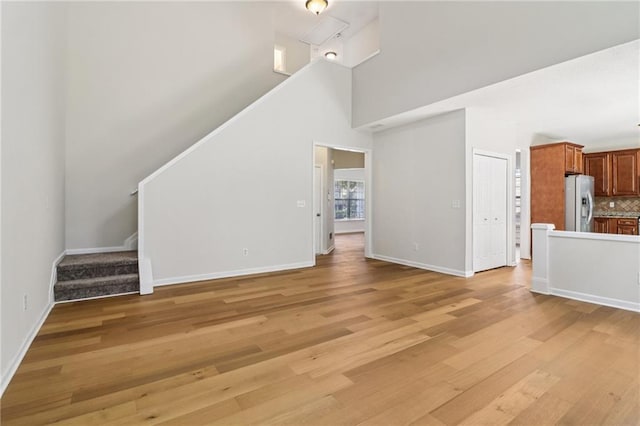 605 Alstonefield Dr, Alpharetta, GA 30004 - unfurnished living room with stairway, light wood-type flooring, and a high ceiling