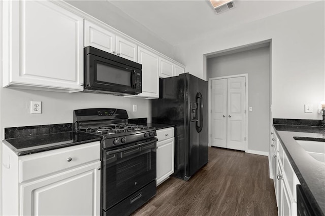 kitchen with visible vents, black appliances, white cabinetry, baseboards, and dark wood-style flooring