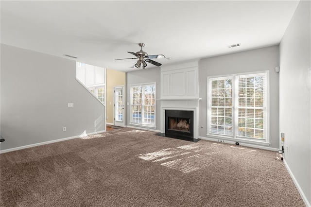 unfurnished living room with visible vents, a large fireplace, and carpet flooring