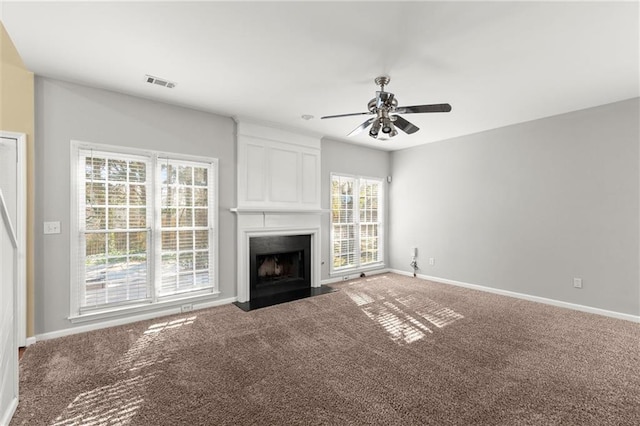 unfurnished living room with baseboards, visible vents, carpet floors, and a large fireplace