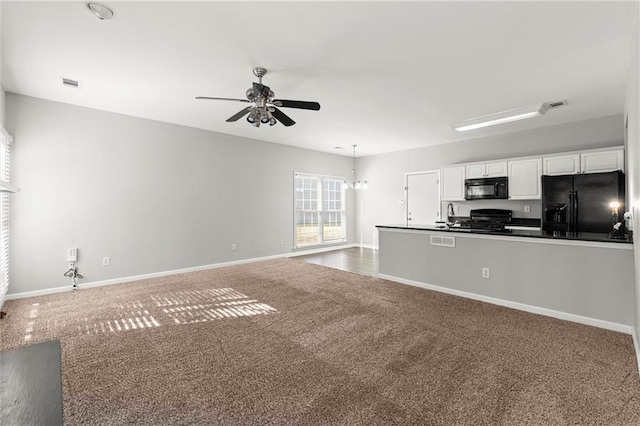 unfurnished living room with baseboards, visible vents, a ceiling fan, and carpet