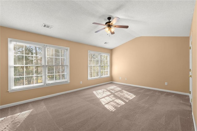 spare room with visible vents, baseboards, carpet, and vaulted ceiling