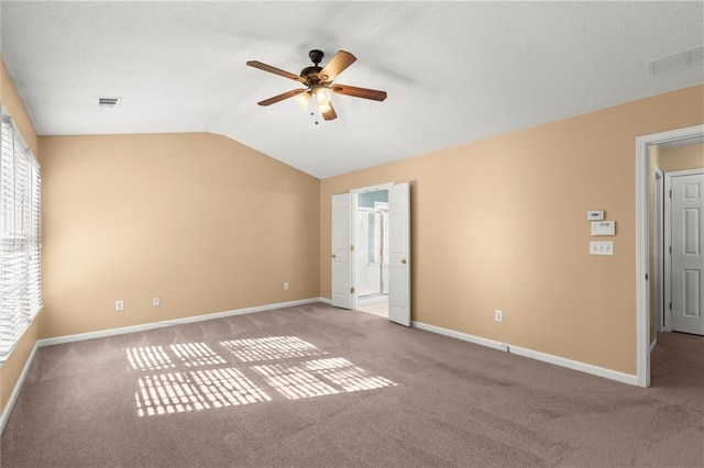 unfurnished bedroom with visible vents, carpet flooring, and vaulted ceiling