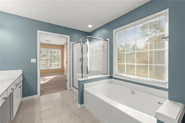 full bathroom with tile patterned floors, a stall shower, baseboards, a bath, and vanity