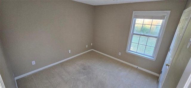 carpeted spare room featuring baseboards