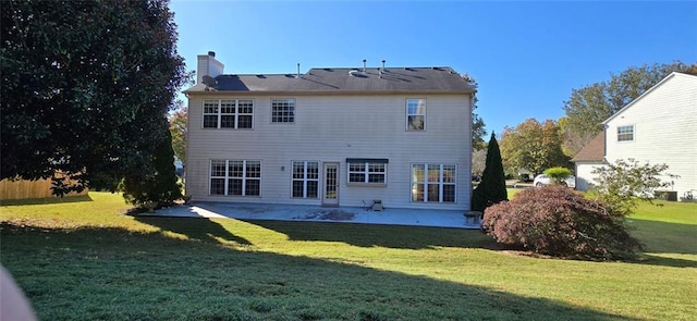 back of house with a patio, a yard, and a chimney