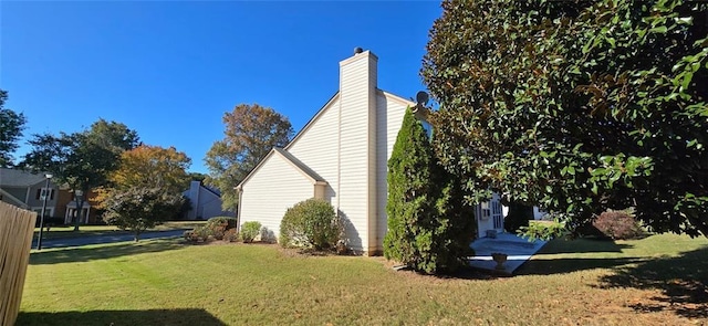 view of home's exterior with a yard and a chimney