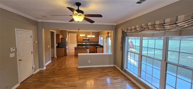 kitchen with dark wood-style floors, appliances with stainless steel finishes, dark countertops, and crown molding