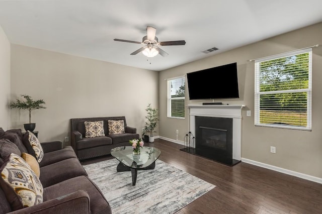 living room featuring ceiling fan and dark wood-type flooring