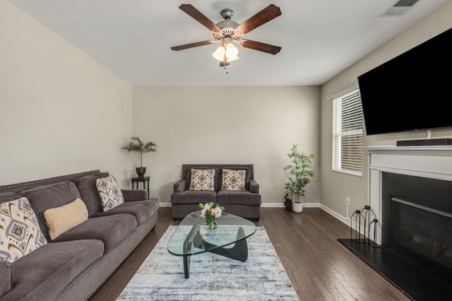 living room featuring ceiling fan and dark hardwood / wood-style flooring