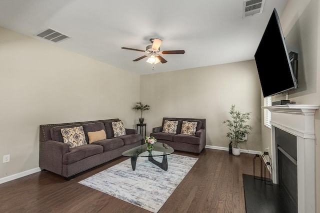 living room with ceiling fan and dark hardwood / wood-style flooring