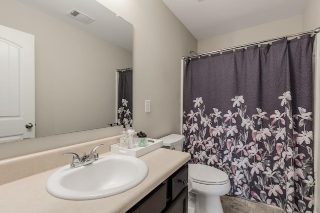 bathroom featuring curtained shower, vanity, and toilet