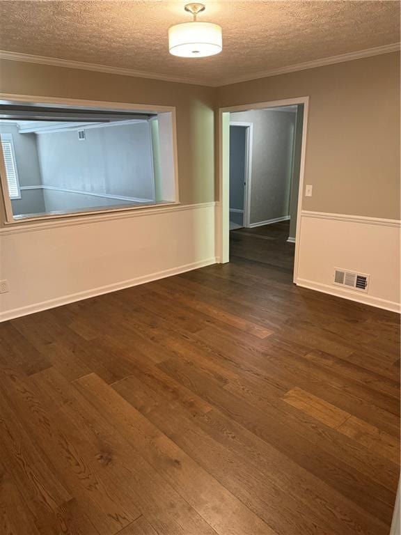 spare room with dark hardwood / wood-style flooring, ornamental molding, and a textured ceiling