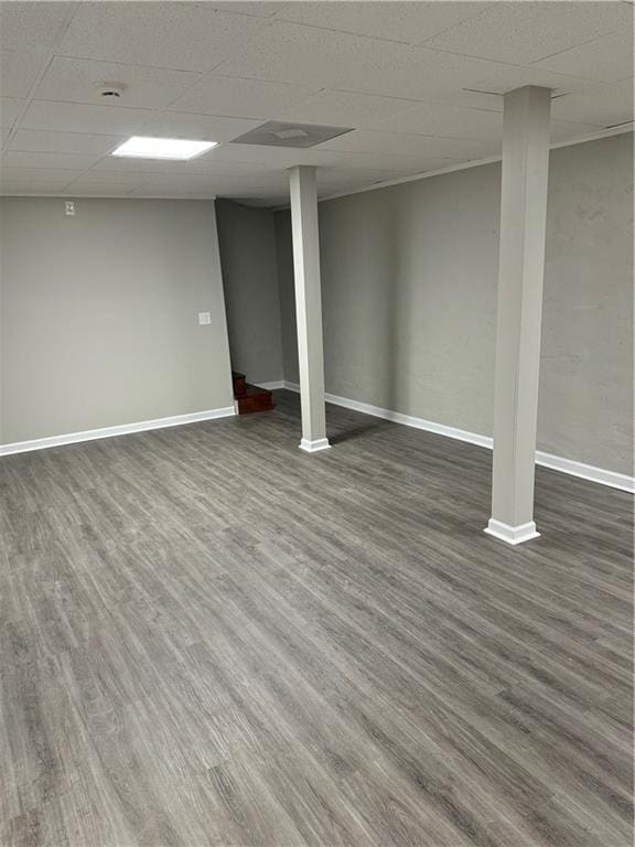 basement featuring dark hardwood / wood-style flooring and a paneled ceiling