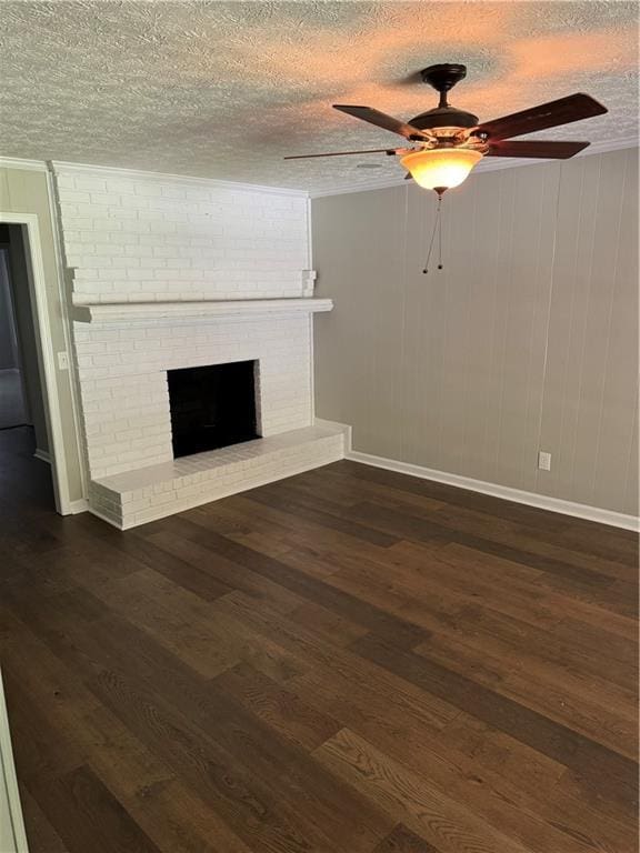 unfurnished living room featuring dark wood-type flooring, ceiling fan, a fireplace, and a textured ceiling