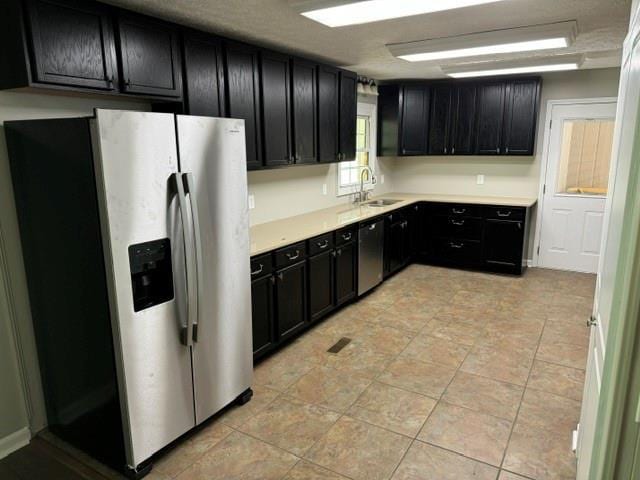 kitchen featuring light tile patterned flooring, stainless steel appliances, and sink