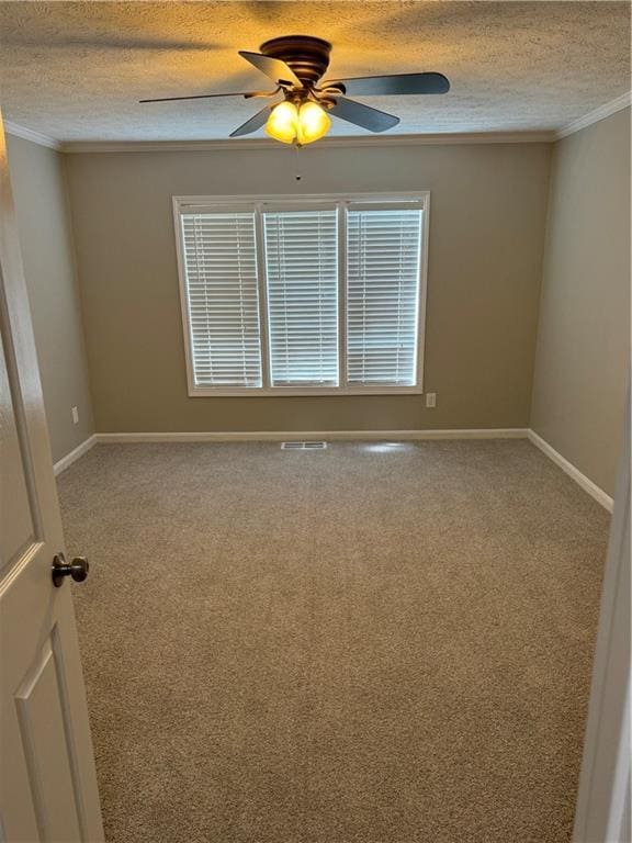 carpeted empty room featuring ceiling fan, ornamental molding, and a textured ceiling