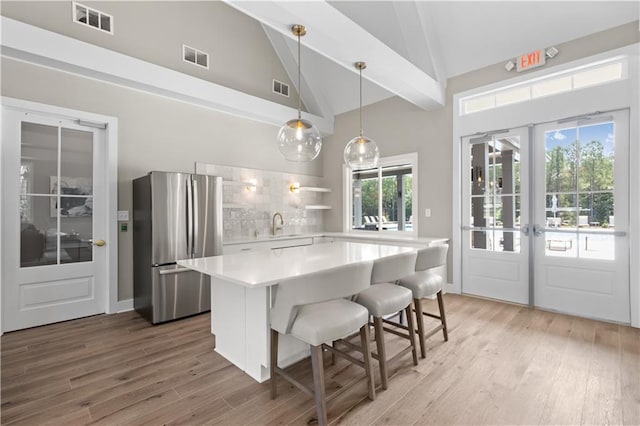 352 Foxglove Way, Mcdonough, GA 30253 - kitchen with freestanding refrigerator, light countertops, light wood-type flooring, french doors, and beamed ceiling