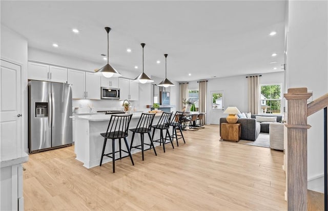 352 Foxglove Way, Mcdonough, GA 30253 - kitchen featuring appliances with stainless steel finishes, light countertops, white cabinets, light wood-type flooring, and recessed lighting