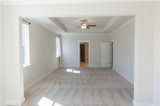 carpeted empty room with a tray ceiling, ornamental molding, and ceiling fan