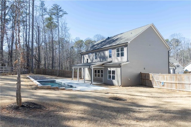 back of house featuring a patio and a fenced in pool