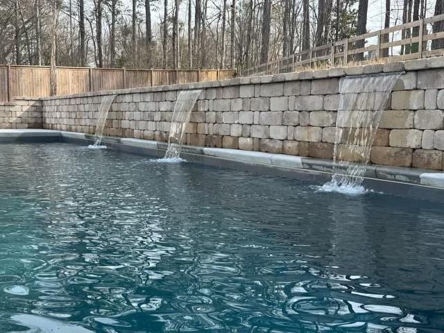 view of swimming pool featuring pool water feature