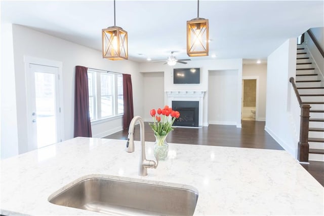 kitchen featuring sink, light stone countertops, and decorative light fixtures