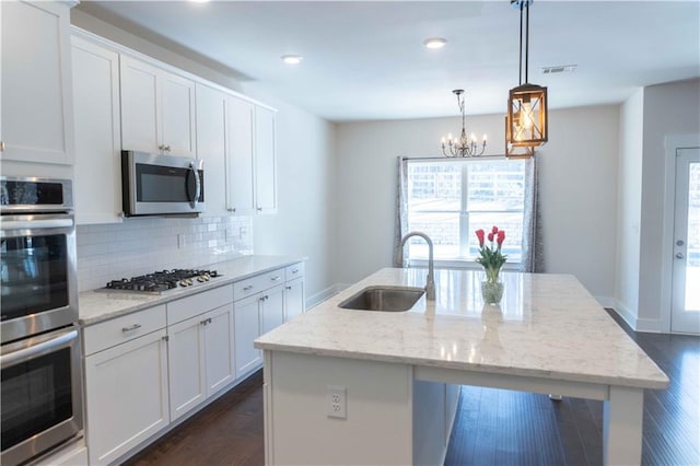 kitchen featuring sink, appliances with stainless steel finishes, a kitchen island with sink, and white cabinetry