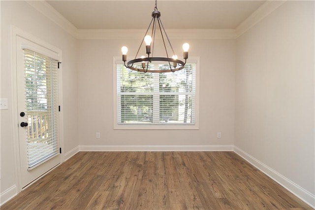 unfurnished dining area with a notable chandelier, a healthy amount of sunlight, and wood finished floors