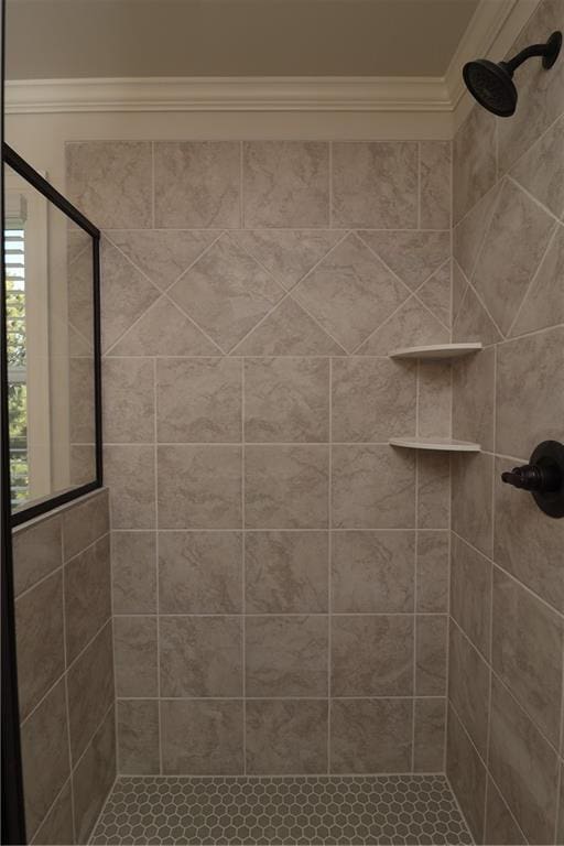 bathroom with a stall shower and crown molding