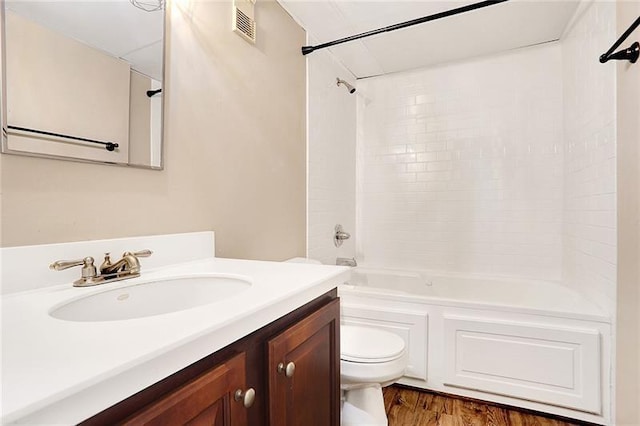 full bathroom with wood-type flooring, bathing tub / shower combination, vanity, and toilet