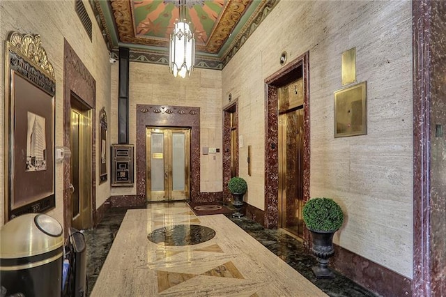 corridor with elevator, ornamental molding, and a high ceiling