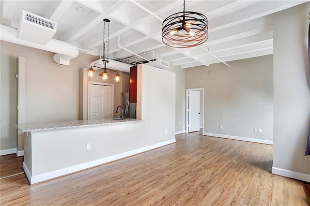 unfurnished living room featuring sink and light wood-type flooring