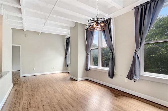 empty room with wood-type flooring and beamed ceiling