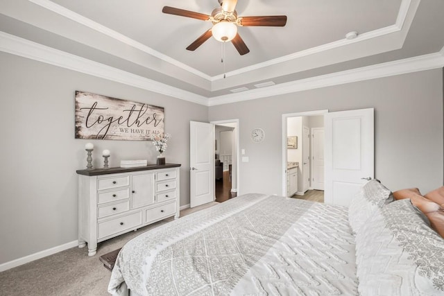 bedroom featuring light colored carpet, crown molding, a raised ceiling, baseboards, and connected bathroom