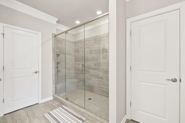 bathroom with baseboards, ornamental molding, a shower stall, and recessed lighting