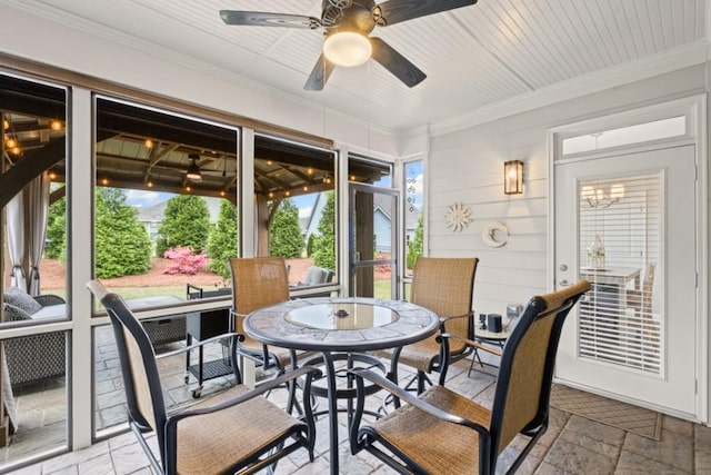 sunroom featuring a ceiling fan and outdoor dining area