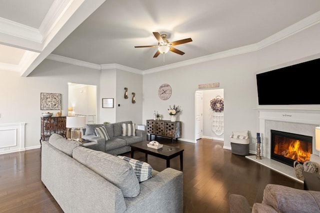 living room with crown molding, a fireplace, a ceiling fan, and dark wood finished floors