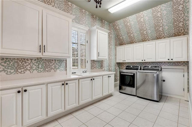 kitchen with washing machine and dryer, sink, white cabinets, and light tile flooring