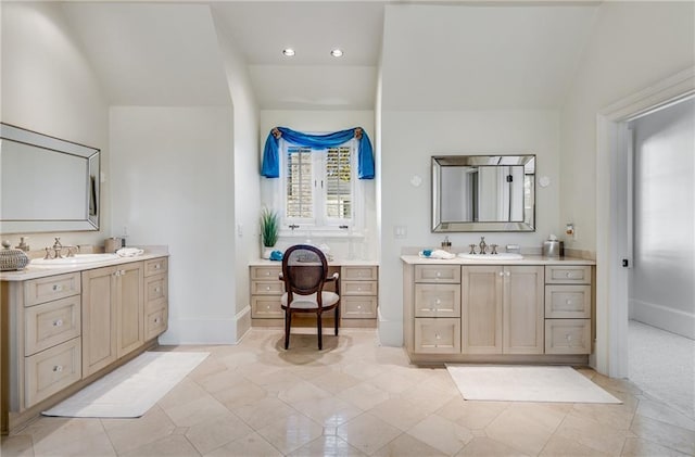 bathroom featuring tile floors, lofted ceiling, and dual bowl vanity