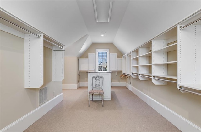 spacious closet featuring light colored carpet and lofted ceiling