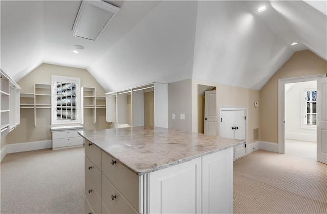 walk in closet featuring light colored carpet and lofted ceiling