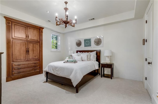 carpeted bedroom featuring a chandelier and a tray ceiling